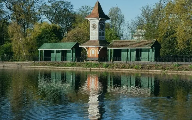 The clock tower and shelters beside the boating lake in Valentines Park, Ilford