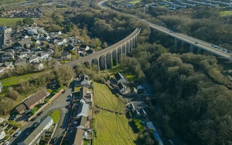 The curved stone Cefn Coed viaduct beside the A465 bridge near Merthyr Tydfil