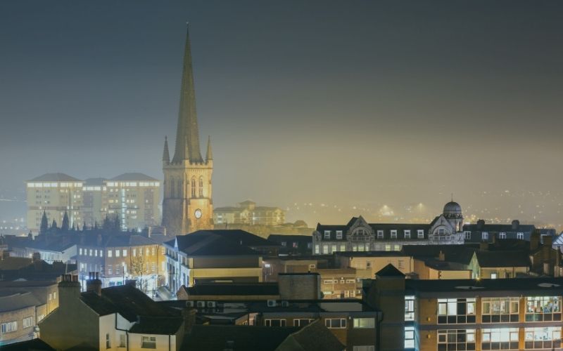 Wakefield Cathedral spire rising above the city rooftops at night