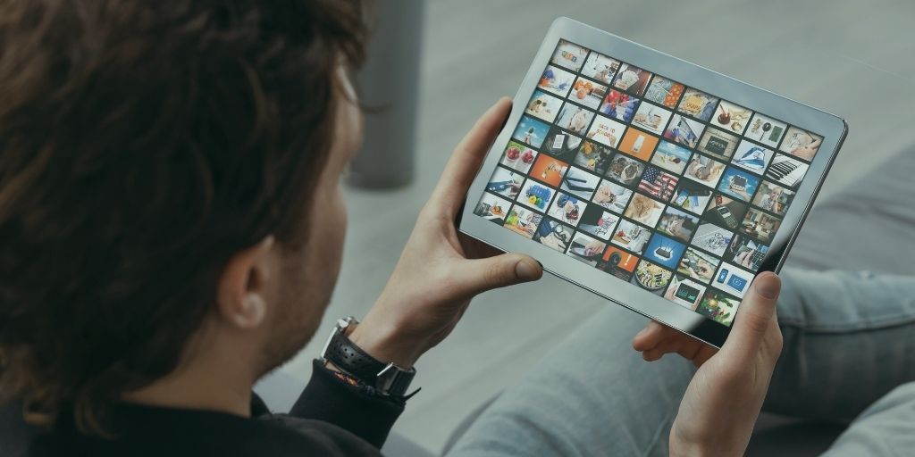 Person browsing a streaming video library on a tablet