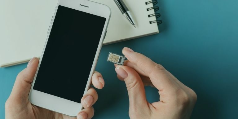 Hands swapping a SIM card into a smartphone