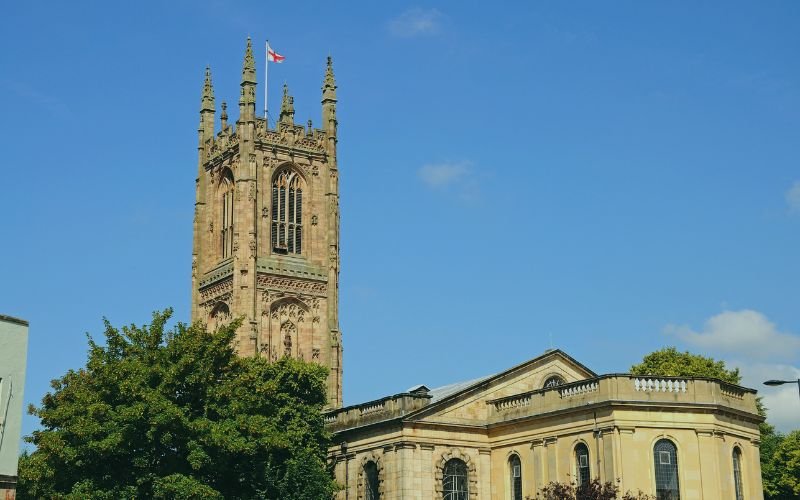 Historic church tower against blue sky - representing broadband in Derby