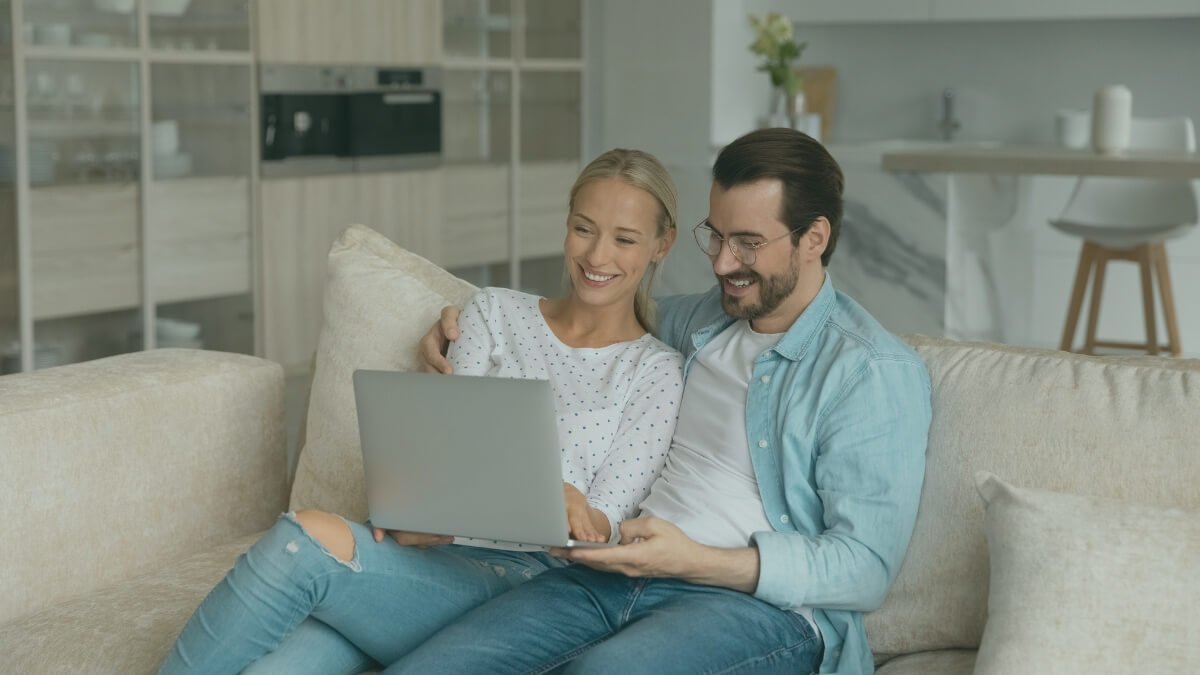 Couple looking into how to Switch Broadband Provider using laptop